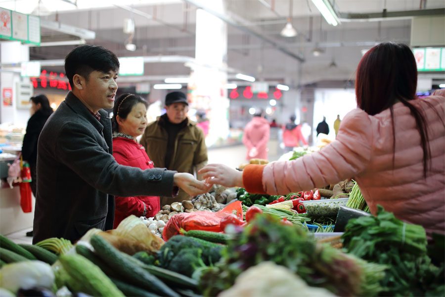 在回去的路上，王亚林到菜市场买些菜回家。