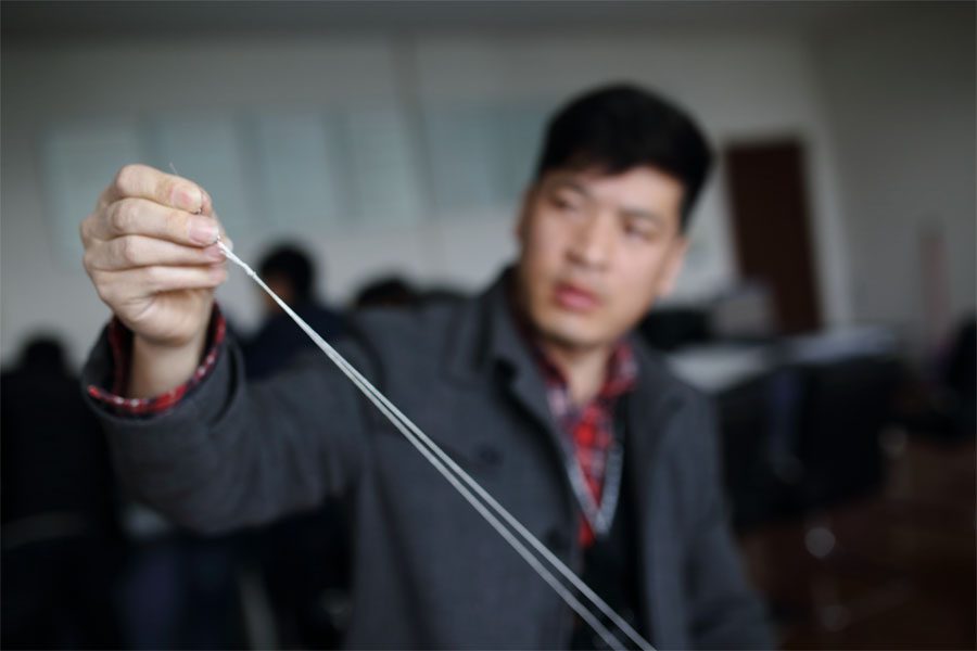 王亚林正在装订气象云图。趁着人员集中开会的时间，部门组织对积攒起来的气象云图进行装订归档。